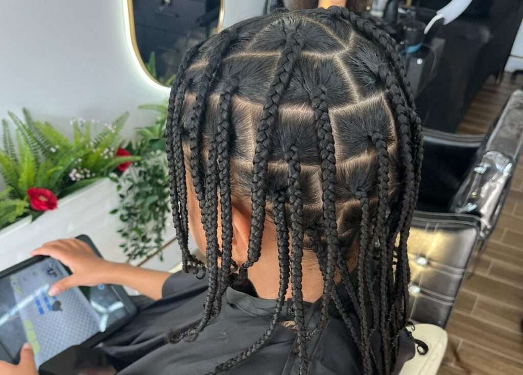 Side view of a client at Lorellin Hair Salon with neat box braids featuring precise sectioning for a clean and stylish protective hairstyle.