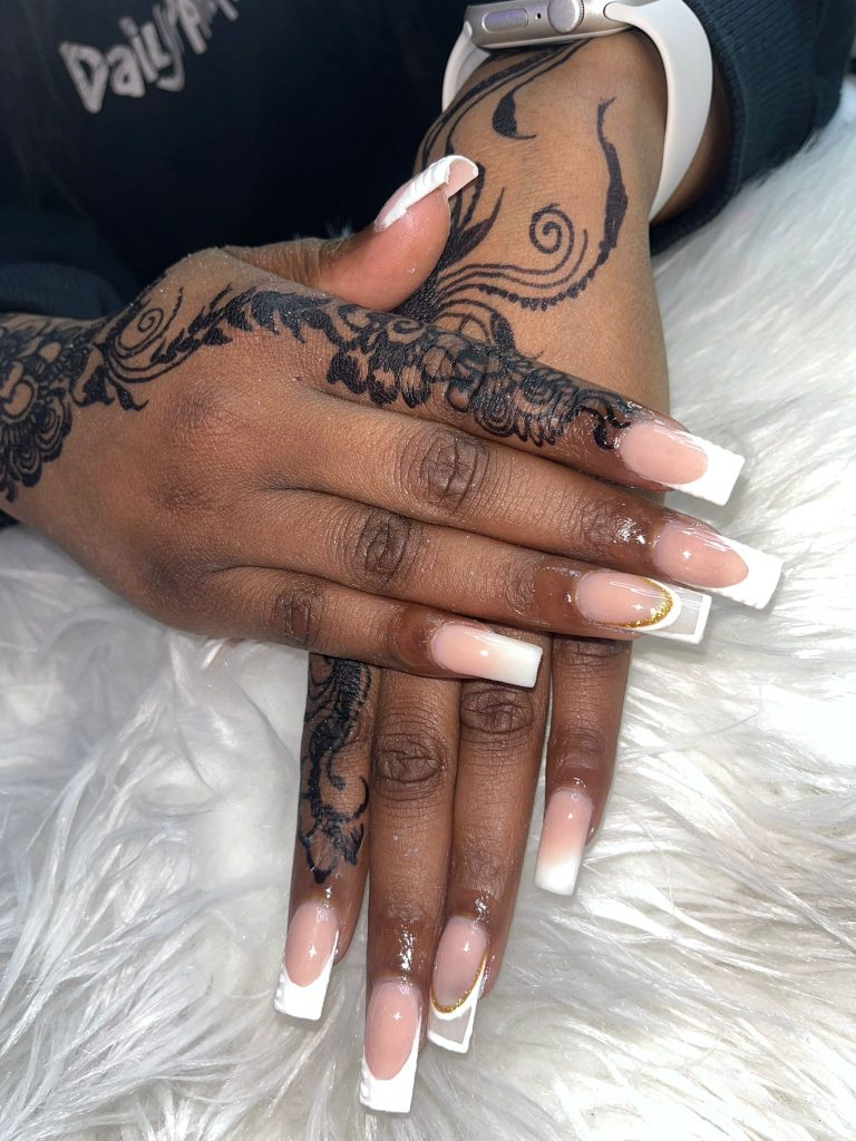 Close-up of classic French tip nails paired with intricate henna artwork, styled at Lorellin Salon.