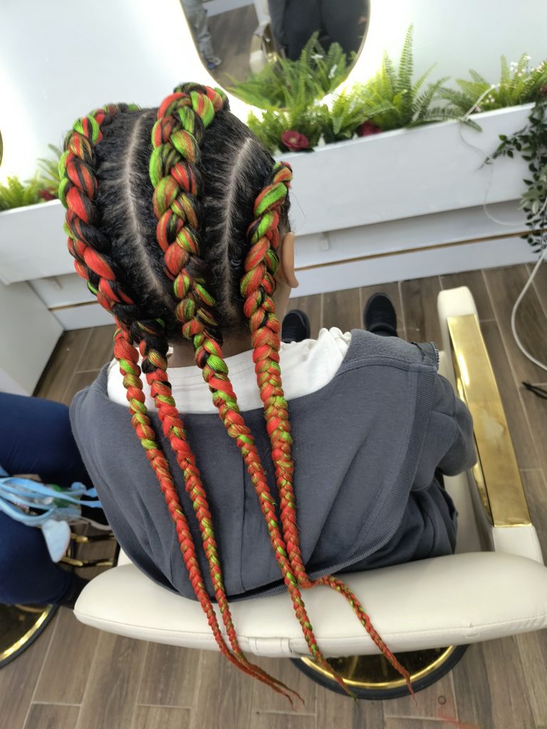 Close-up of bold red and green cornrows with clean partings, styled at Lorellin Salon in Bilston.