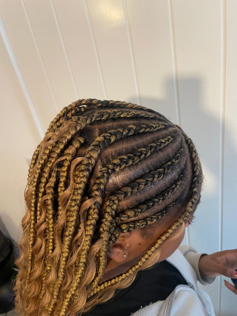 Close-up of blonde knotless braids with neat parting by Lorellin Hair & Beauty in Wolverhampton