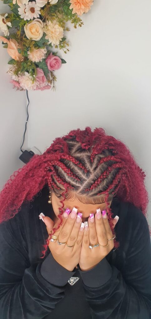 Red braided cornrows with curved pattern by Lorellin Hair & Beauty in Wolverhampton